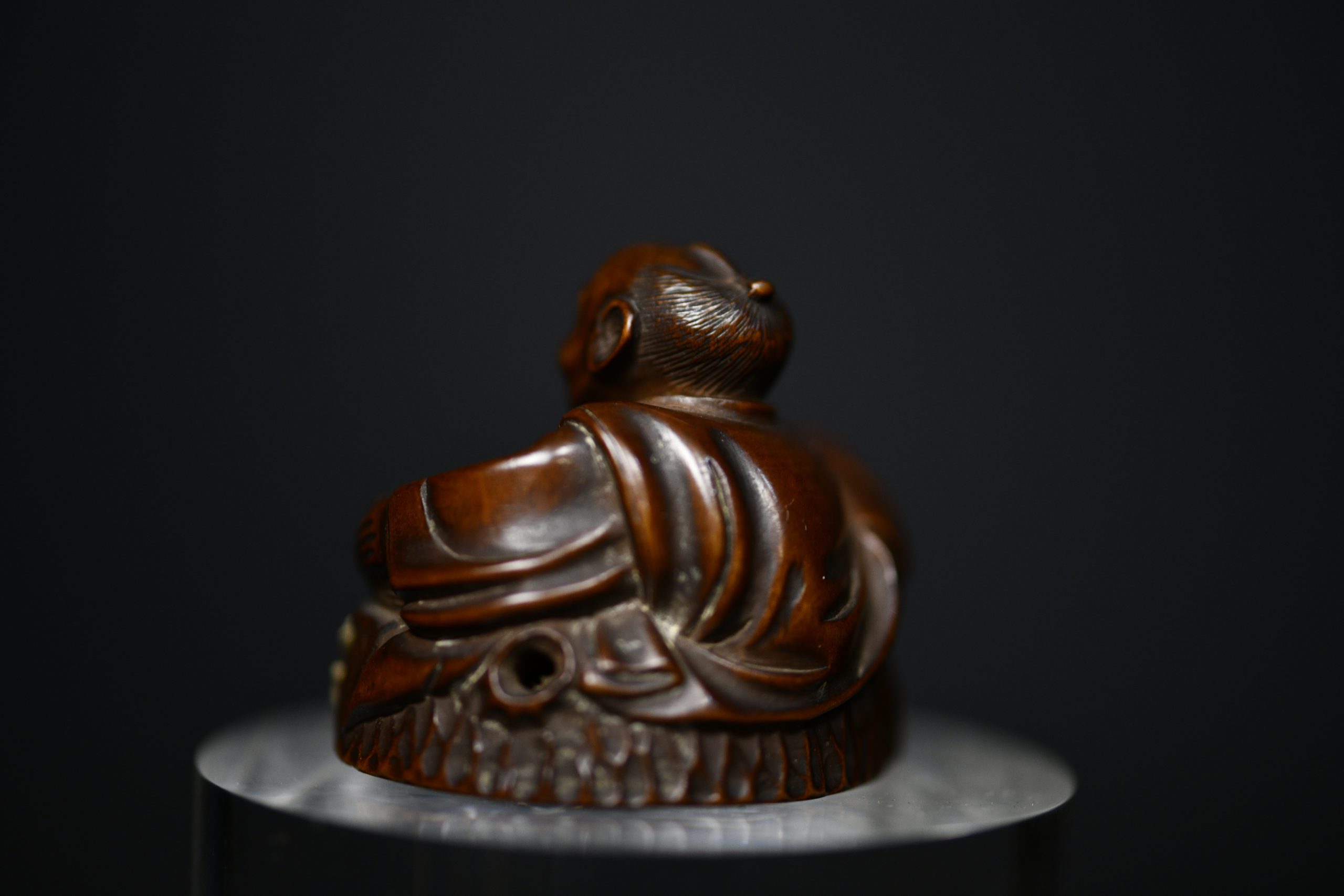 Netsuke man on stump wood