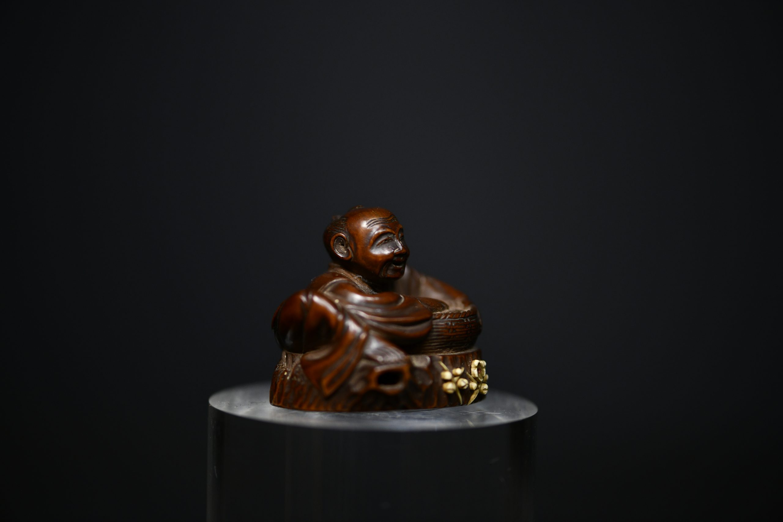 Netsuke man on stump wood