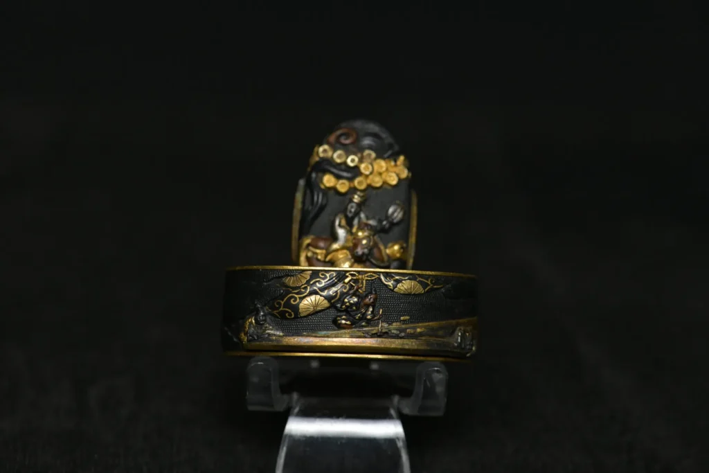 Fuchi-kashira de shakudō con carpinteros
